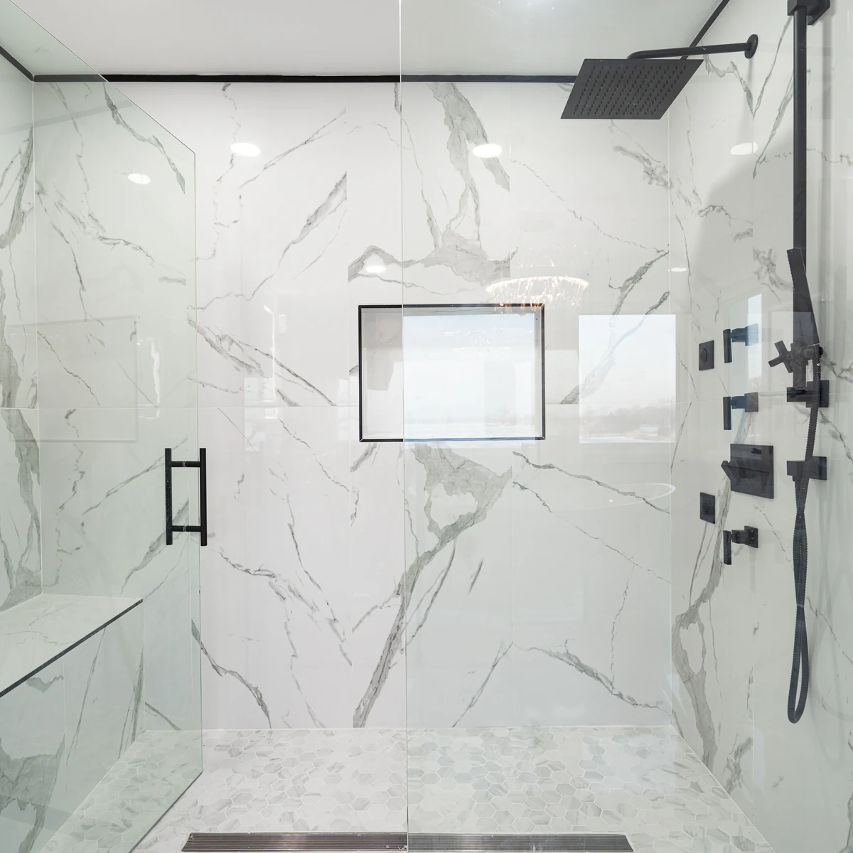 Badewanne raus, Dusche rein: bodengleiche Dusche mit Glastür, Wänden in Marmoroptik und Duschrinne