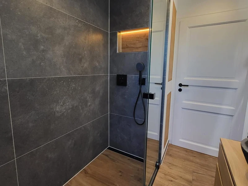 Neue Dusche bodengleich eingebaut: Der Holzoptik-Boden läuft ohne Schwelle in die Dusche mit Glastür