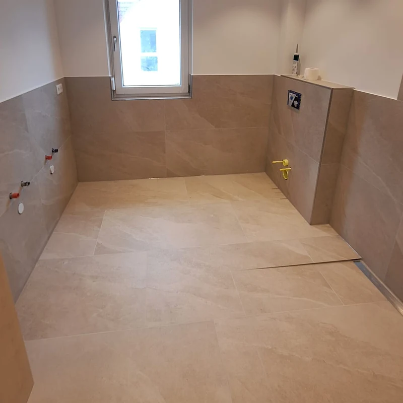 Dusche erneuern: neu gefliester Boden mit Duschrinne, Armaturen und Glaswand werden erst danach montiert